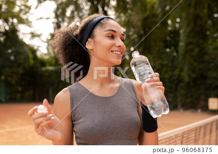 Cute young girl feeling thirsty after workout 96068375
