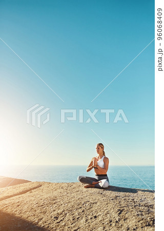 Everyone should practice yoga. Shot of a young woman doing yoga at the beach. Everyone should practice yoga. Shot of a young woman doing yoga at the beach. 96068409
