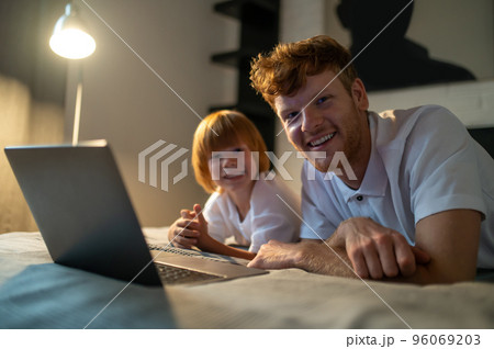 Dad and son spending time together in bed before going to sleep 96069203