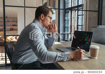 Serious crypto trader analyzing risks of buying cryptocurrency in global recession looking at chart Serious crypto trader analyzing risks of buying cryptocurrency in global recession looking at chart 96069204