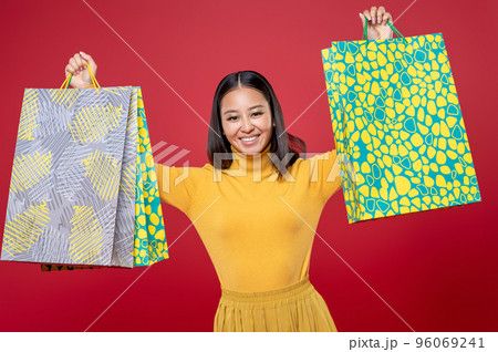 Cheerful beautiful fashionista showing off her purchases 96069241