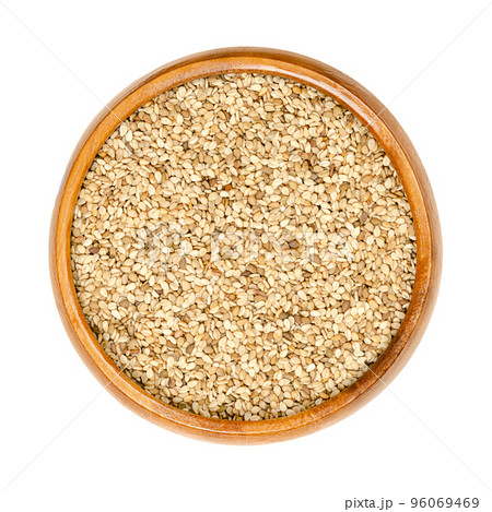 Unhulled sesame seeds, benne in a wooden bowl. Seeds of Sesamum indicum, with rich and nutty flavor. Common ingredient in cuisines around the world, with one of the highest oil content of any seed. 96069469