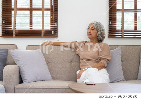 Asian elderly senior female at nursing home living room feeling sad missing unhappy thoughtful in mental health care in older people. 96070030