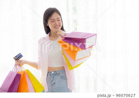 Young asian woman standing holding credit card and paper bag with satisfied. Young asian woman standing holding credit card and paper bag with satisfied. 96070627