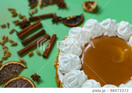Caramel cake with nuts and caramel sauce glaze. whipped cream with cinnamon. rounded tart or pie 96073372