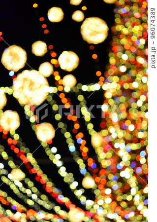 New Year's Christmas tree decorated with luminous multi-colored garlands and illumination at night. Christmas tree with flashing lights. Blurred background. New Year Christmas holidays. 96074389