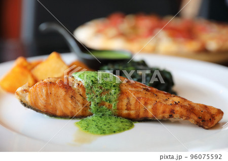 Salmon steak with pesto sauce Salmon steak with pesto sauce 96075592