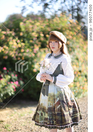 A beautiful woman in lolita dress in garden background Japanese street fashion portrait 96077400
