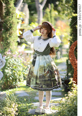 A beautiful woman in lolita dress in garden background Japanese street fashion portrait 96078407