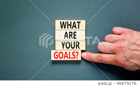 What are your goals symbol. Concept words What are your goals on wooden blocks. Beautiful grey table grey background. Businessman hand. Business psychological what are your goals concept. Copy space 96079276
