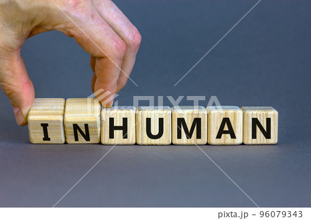 Human or inhuman symbol. Businessman turns wooden cubes and changes the word inhuman to human. Beautiful grey table grey background, copy space. Business, human or inhuman concept. Human or inhuman symbol. Businessman turns wooden cubes and changes the word inhuman to human. Beautiful grey table grey background, copy space. Business, human or inhuman concept. 96079343