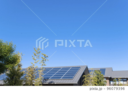 【環境イメージ】太陽光パネルが設置された住宅の屋根と快晴の青空。 96079396