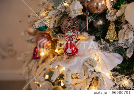 White Christmas tree with vintage toys, balls, garlands on a spruce branches with artificial snow, copy space. 96080701