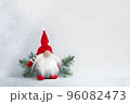 Christmas gnome in red cap with fir branch holiday invitation card on light winter background 96082473