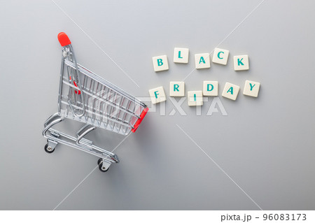Black friday text and shopping cart on gray background. Top view. 96083173