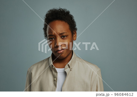 Dissatisfied schoolboy in casual shirt looking at camera 96084612