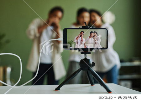 Group of happy intercultural kids performing song on smartphone screen Group of happy intercultural kids performing song on smartphone screen 96084630