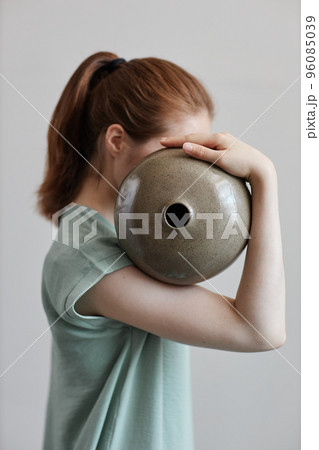 Concept portrait of young woman holding ceramics Concept portrait of young woman holding ceramics 96085039