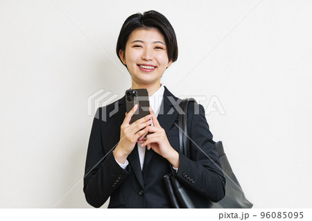 スマホを持つスーツ姿の若い女性 96085095