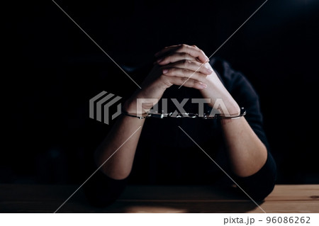 Unrecognizable hacker in handcuffs 96086262