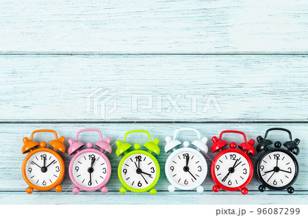 The Many different alarm clocks on blue wooden background with copy space for your text or message. 96087299