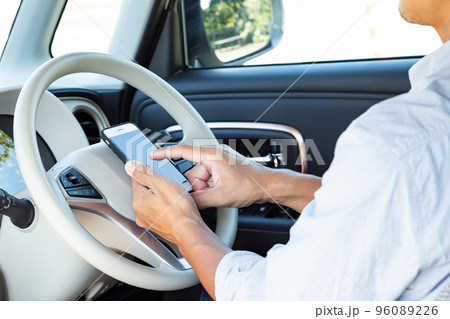 運転中にスマホを操作する男性 運転中にスマホを操作する男性 96089226