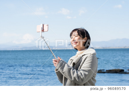 冬の海岸で自撮りする女性 96089570