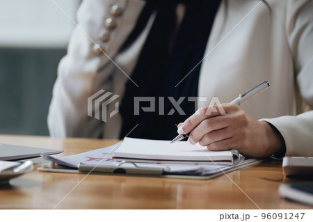 Asian businesswoman taking business notes while talking on the phone. 96091247