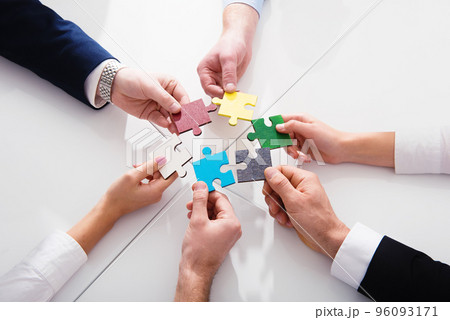 Teamwork of partners. Concept of integration and startup with puzzle pieces Teamwork of partners. Concept of integration and startup with puzzle pieces 96093171