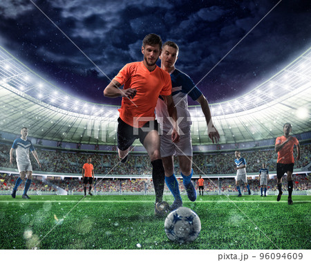 Football scene with competing football players at the stadium 96094609