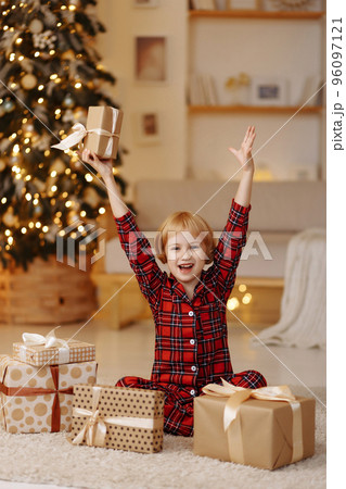Girl sitting on the floor with a gift in a box 96097121