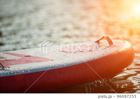 Close up of a stand up paddle board SUP and paddle on a dock Close up of a stand up paddle board SUP and paddle on a dock 96097255