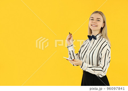 Concept of occupation, young female waiter on yellow background 96097841
