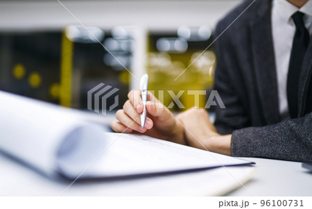 Pen in office worker hand. Close up of the hands of a businessman in a suit signing a document. Pen in office worker hand. Close up of the hands of a businessman in a suit signing a document. 96100731