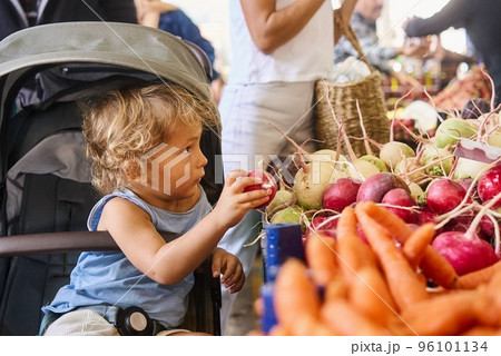 Cute boy with his mother buying fresh vegetables at the farmer's market 96101134