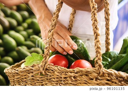 a customer choosing avocados in the local market  96101135