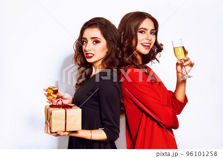 portrait of two happy young women who make selfie. in evening dresses on party over white background. 96101258