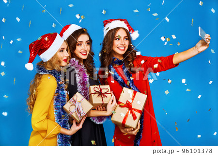 portrait of three happy young women in santa claus hat with gift .Christmas concept. portrait of three happy young women in santa claus hat with gift .Christmas concept. 96101378