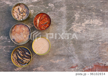 Different open canned food on old wooden background. Top view. Flat lay. 96102654