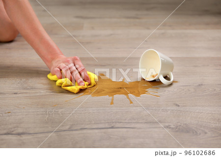 A cup of coffee fell on laminate, coffee spilled on floor. 96102686