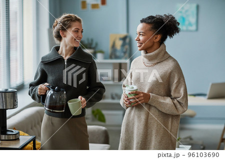 Colleagues drinking coffee at office 96103690
