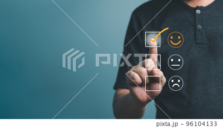 Customer service and Satisfaction concept ,Business people are touching the virtual screen on the happy smiley face icon to give satisfaction in service. rating very impressed.. 96104133