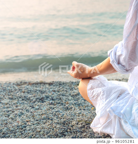 Woman meditating at the Garda Lake. Sunset. 96105281