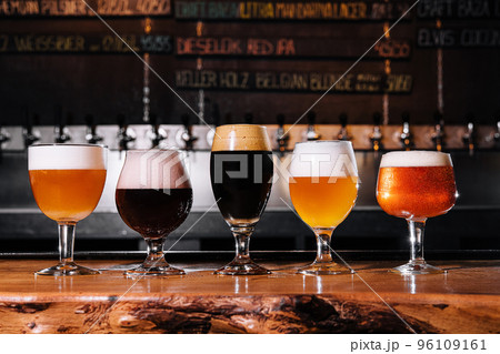different types of craft beer in glasses on table in pub interior in daylight 96109161