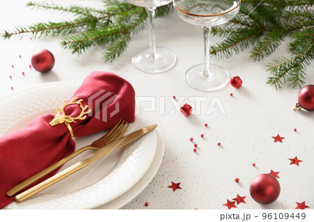 Christmas table setting with elegant red decorations on white table. Christmas table setting with elegant red decorations on white table. 96109449