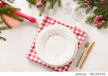 Christmas table setting with elegant red decorations on white table. View from above. Christmas table setting with elegant red decorations on white table. View from above. 96109450
