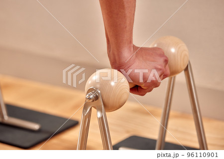Man doing a handstand push-up using floor bars balancing on his hands. Fitness concept 96110901