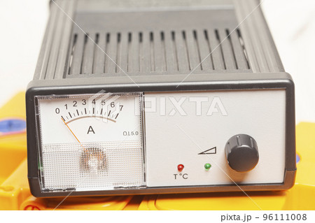 yellow car battery with car battery charger isolated on white background 96111008