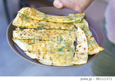 Traditional Turkish food cuisine. Gozleme bread on a plate. Dish stuffed with cheese and herbs. High quality photo 96111371