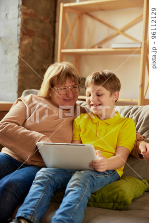 Happy grandmother and grandson spending time together at home. Concept of emotions, family, happiness, care, support and leisure activities 96112129